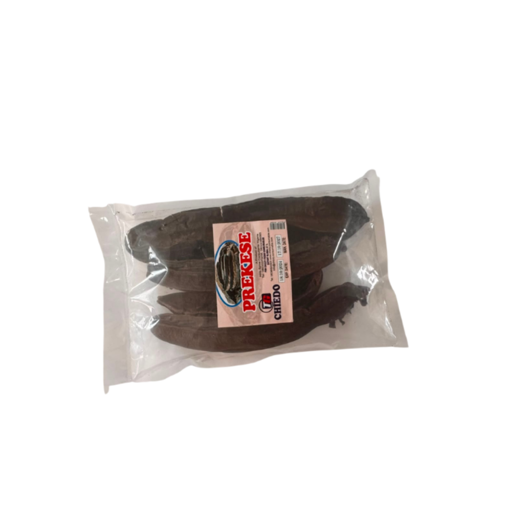 A vacuum-sealed package containing several dark brown dried peppers, with a white and red label on the front, isolated on a white background.